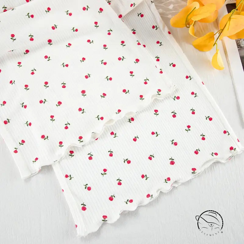 White ribbed knit langry cardigan with red floral pattern and lettuce-edge trim