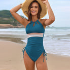 Teal one-piece swimsuit with cutouts and side ties for stylish beach fashion ملابس