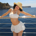 Woman in white swimwear and straw hat showcasing stylish langry summer fashion set