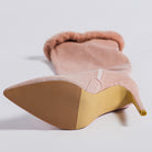 Pink faux fur-trimmed high leg boot with stiletto heel showcasing stylish design