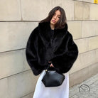 Cozy short faux fur coat in black with high collar and long sleeves