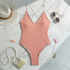 Peach-colored ribbed one-piece swimsuit with criss-cross straps for stylish swimwear fashion
