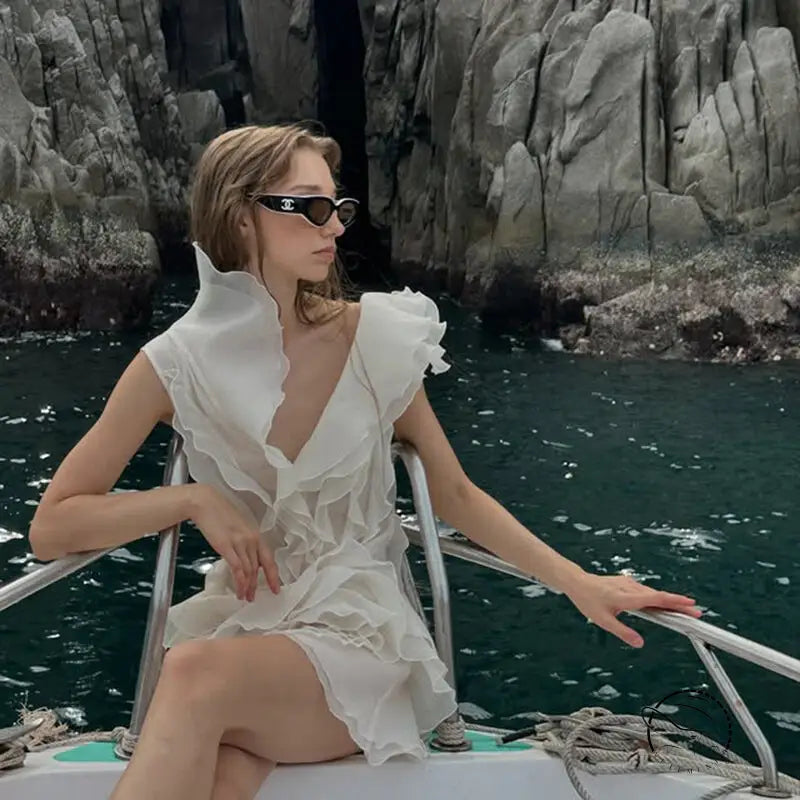 Woman in white ruffled off-shoulder langry fashion dress and sunglasses