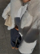 White fluffy faux fur coat with black trim and warm pockets