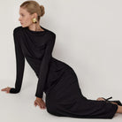 Black long-sleeved maxi dress with high neckline and flowing silhouette