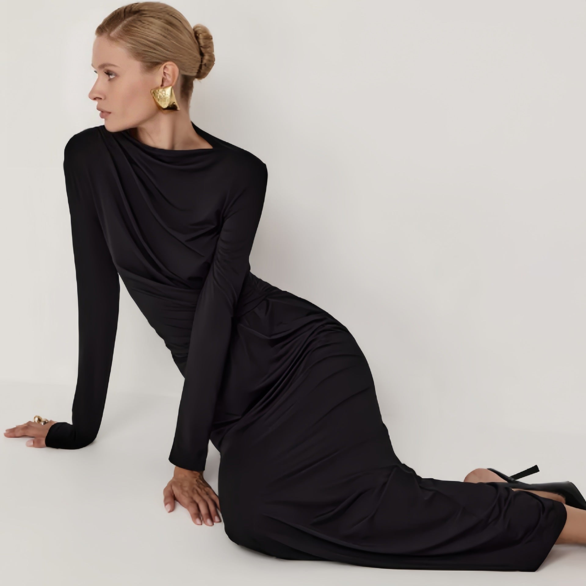 Black long-sleeved maxi dress with high neckline and flowing silhouette