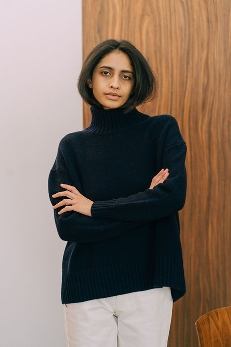 Langry fashion black turtleneck sweater with white pants on wooden door