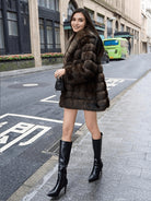 Casual warm mid-length faux fur hooded coat with black high-heeled boots and purse
