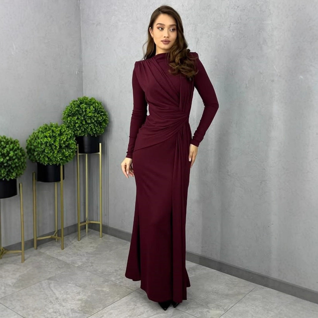 Sleek burgundy long-sleeved maxi dress with draped neckline and fitted silhouette