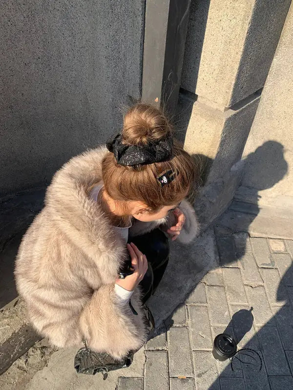 Winter faux fur jacket with black leather accents and pom-pom detail