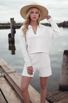 Woman in loose stylish shorts knitting set with straw hat