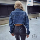 Woman in matching denim short coat with cropped jacket and faux leather leggings