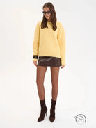Yellow wool alpaca winter loose long sweater with black sunglasses and brown leather boots