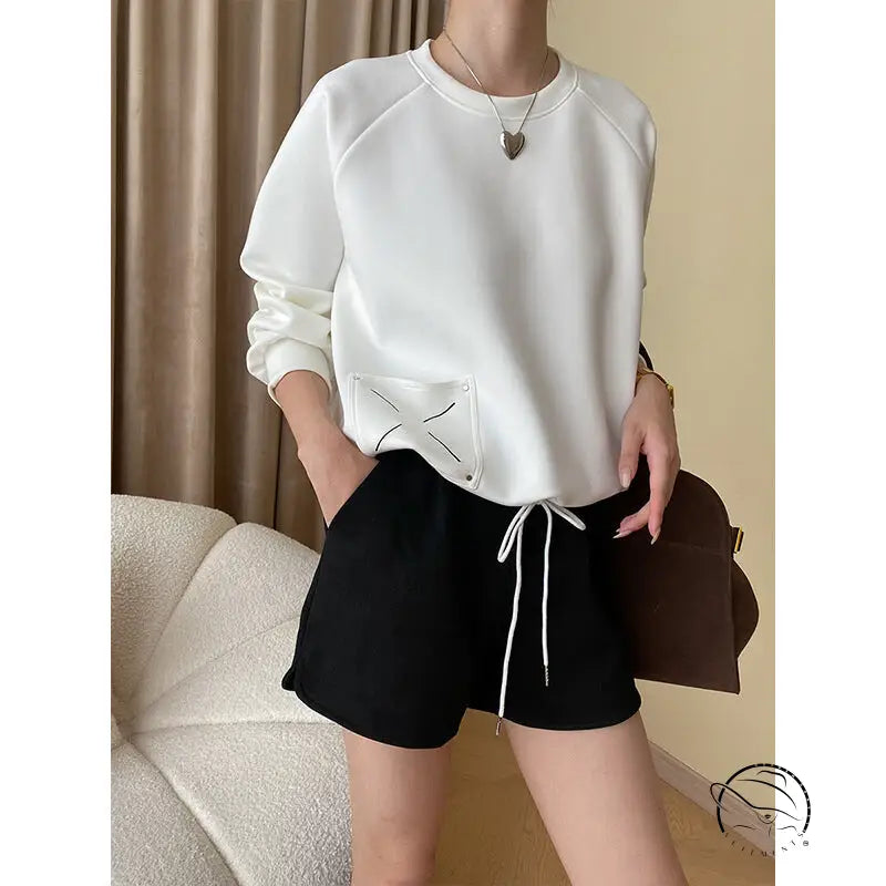 White raglan-sleeved langry fashion sweatshirt with black X embroidery pocket