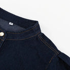 Close-up of dark blue denim shirt fashionable with orange stitching and gold button