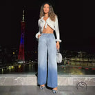 Woman in cropped fur-trim top, light-wash high-waist denim trousers, silver heels