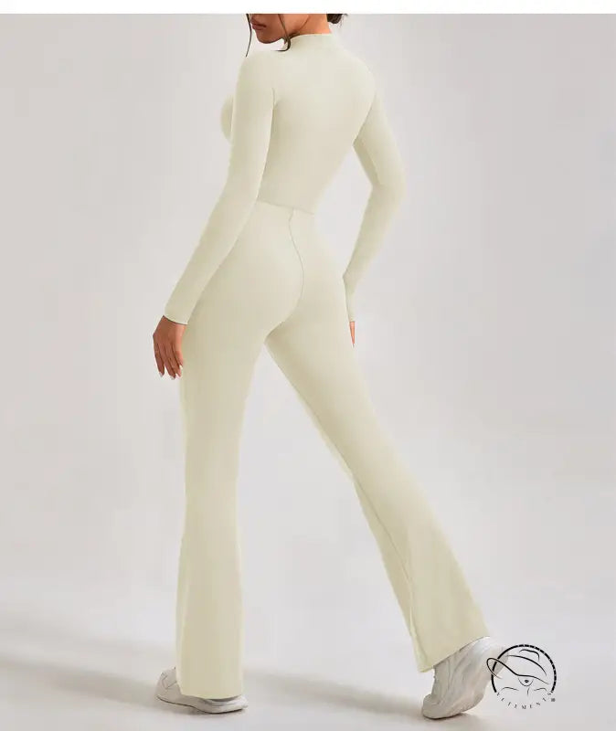 Cream-colored long-sleeve one piece sportswear jumpsuit with flared legs