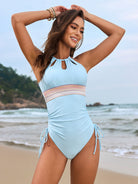 Light blue one-piece swimsuit with stripes and side ties, ideal for fashion enthusiasts