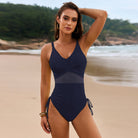 Navy blue one-piece swimsuit with mesh panel detail and side ties for stylish beach fashion