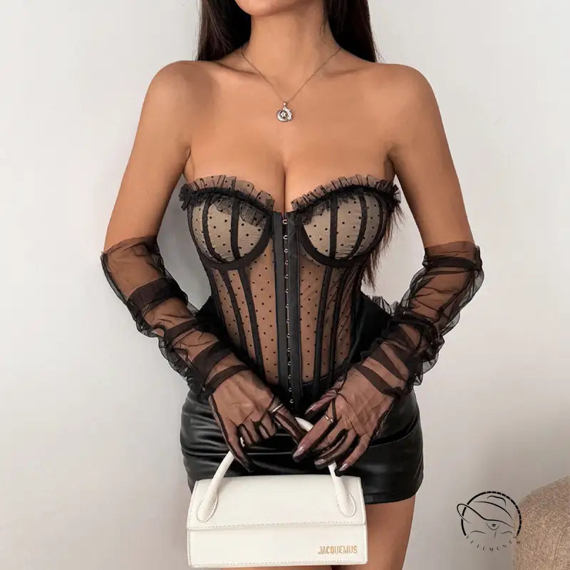 Black polka dot lace corset with sheer sleeves and white leather handbag