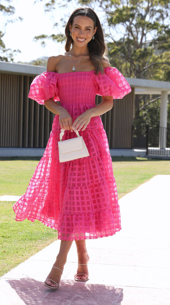 Woman in a pink off-the-shoulder Enchanting Lantern Sleeve Dress, showcasing stylish ملابس