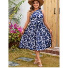 Woman in a blue and white leaf-patterned dress showcasing elegant fashion for ملابس
