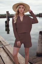 Woman in loose stylish shorts knitting set with straw hat