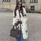 Cozy faux fur long coat in cow print with brown leather accents