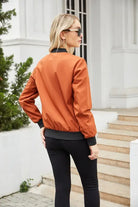 Blonde woman in orange bomber jacket showcasing Army Green Casual Varsity Jacket features