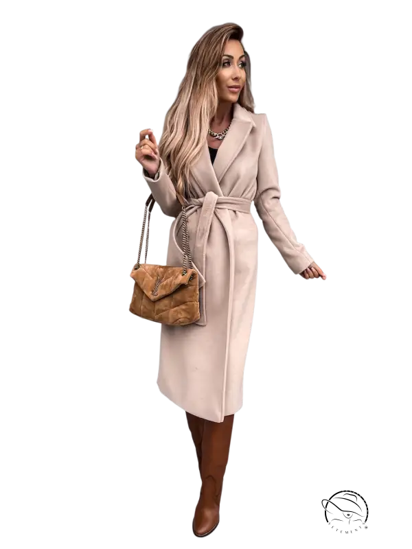 Woman in army green polo collar long sleeved belted coat with blonde hair and brown boots