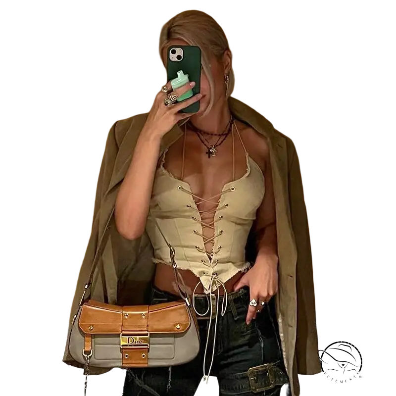 Woman taking mirror selfie wearing a backless bandage corset top with jacket and designer handbag