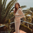 Woman in a crocheted dress showcasing the Boho Long Sleeve Maxi Dress for summer beach vacations