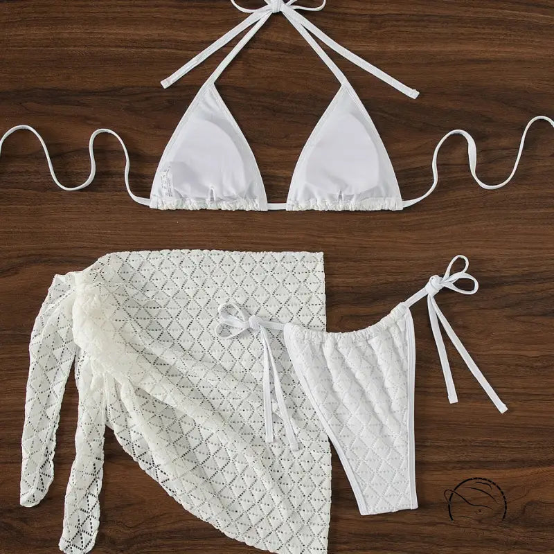 White bikini set with a matching lace cover-up skirt.
