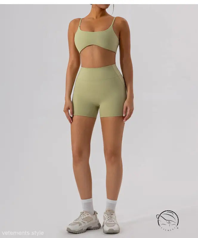 Woman in close fitting yoga shorts in oat apricot green athletic set