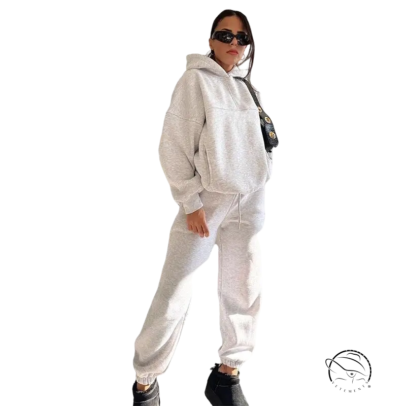 Woman in white casual comfy sweatsuit and sunglasses for winter