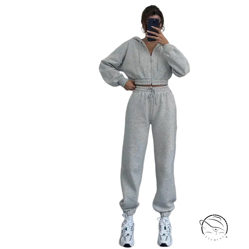 Person in casual exercise suit with hooded zipper taking mirror selfie