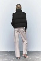 Woman’s black puffer vest paired with light pink pants for autumn winter short jacket