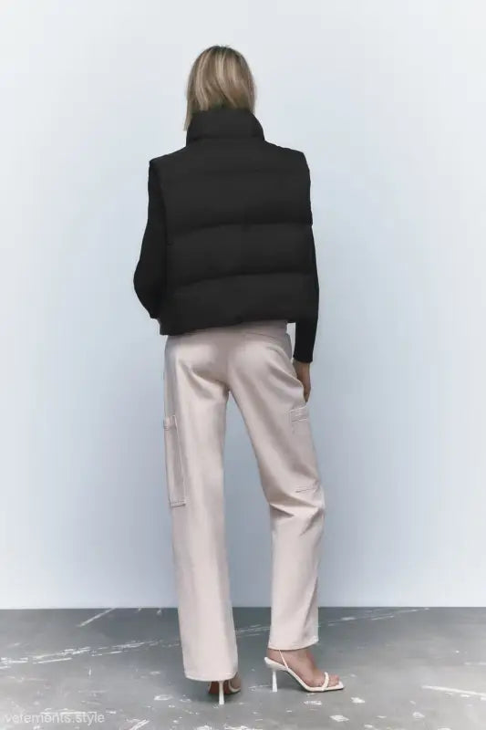 Woman’s black puffer vest paired with light pink pants for autumn winter short jacket