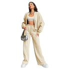 Woman in beige tracksuit featuring a zipper cardigan sweater and casual straight pants