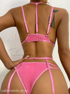 Pink lingerie set with strappy details on dark skin model, showcasing a sexy four piece design