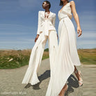 Two women in white outfits showcasing the Clara Blazer Suit and Zipper Trousers Lace