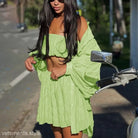 Woman in lime green outfit beside motorcycle, showcasing comfy white summer three-piece set