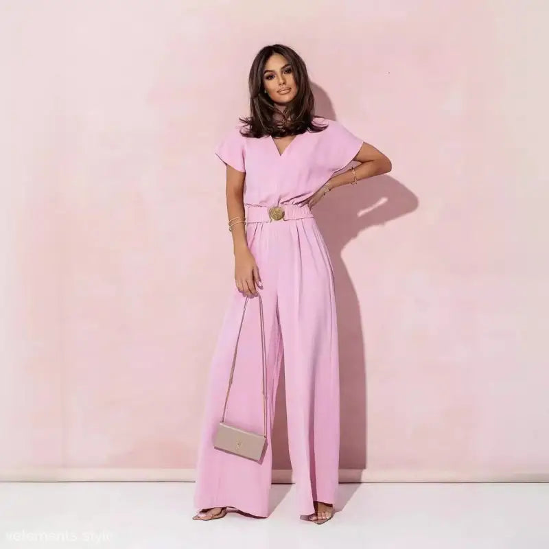 Woman wearing coral red casual trousers jumpsuit with short sleeves and wide-leg pants