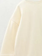 Cream-colored cute pattern sweater featuring a round neckline and dropped shoulder seam
