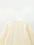 Cream-colored cute pattern sweater featuring a round neckline for girls’ clothing