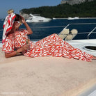 Woman in red and white dress on a boat deck featuring an Elegant Black Off-Shoulder Set