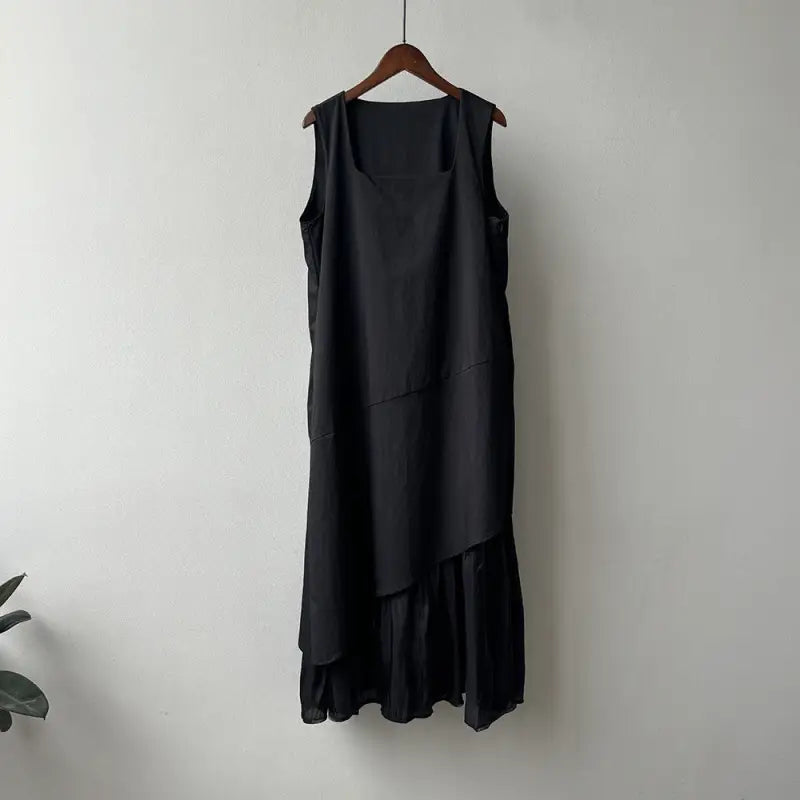 Black sleeveless hem stitching dress with asymmetrical ruffled hem on wooden hanger