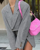Houndstooth blazer with pink purse showcasing a French casual blazer style
