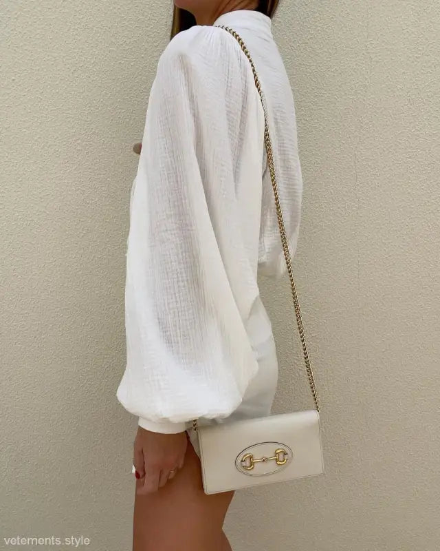 White linen lantern sleeve shirt styled with a cream handbag for office elegance
