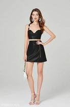 Woman in black elegant leather set with zipper V-neck top and hip skirt for summer